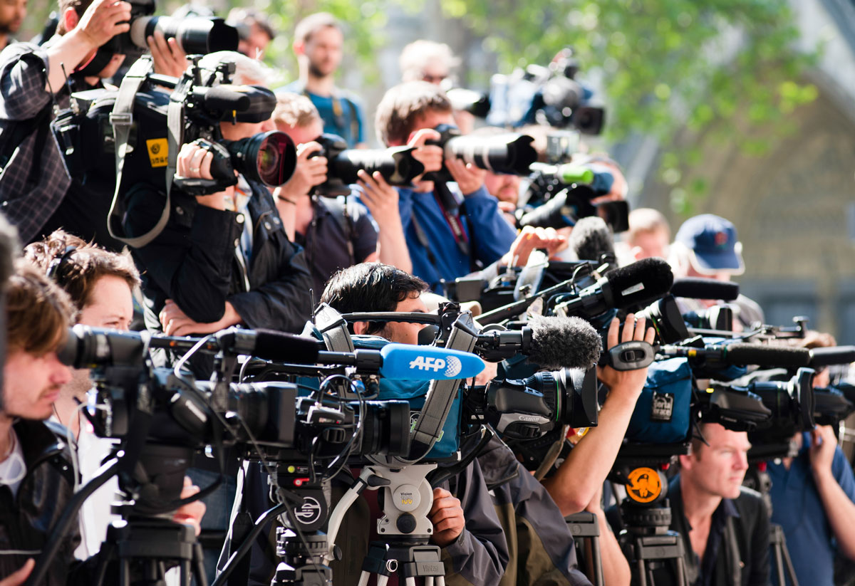 large group of television cameras lined up to shoot a big event