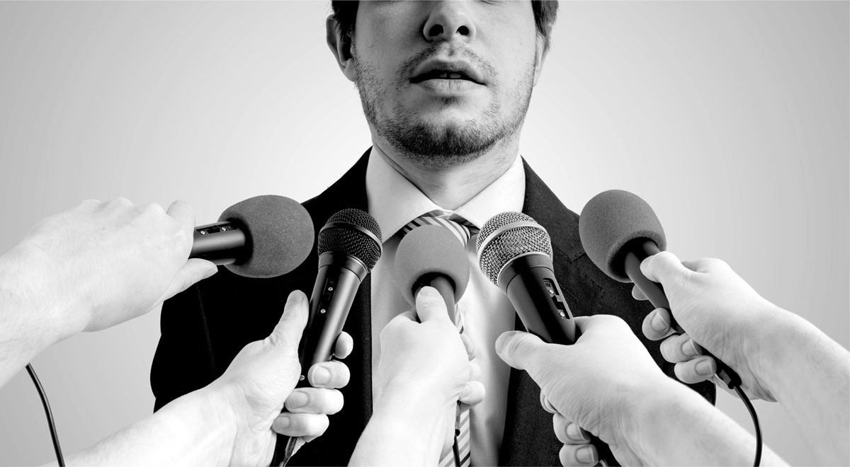 franchise executive with multiple microphones in his face